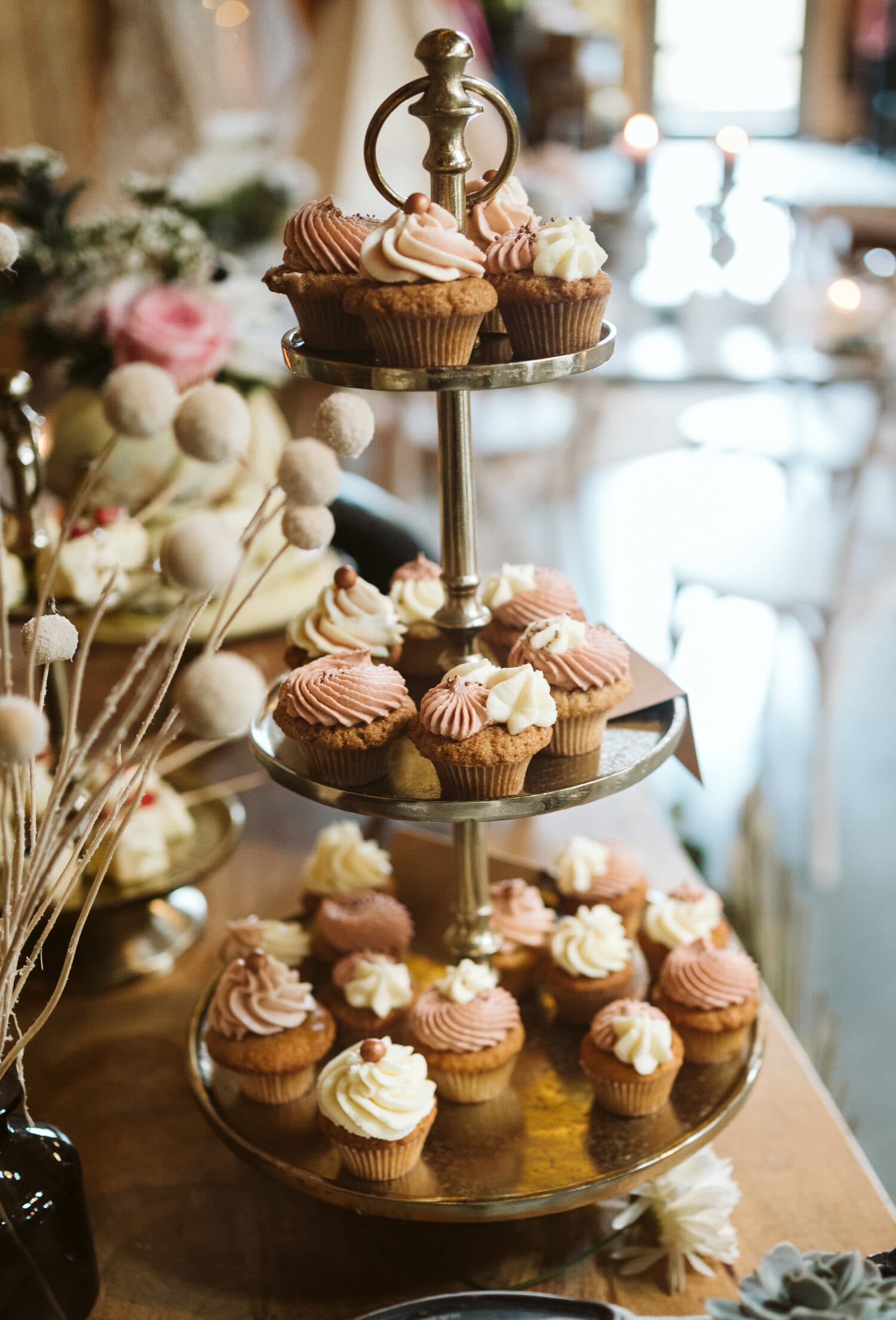 Dreistöckige Etagere mit Cupcakes in Rosé und Creme, dekoriert mit Trockenblumen